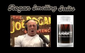 Joe Rogan reacting to smelling salts with a bottle of Ahhh!!! World's Strongest Smelling Salts displayed next to him